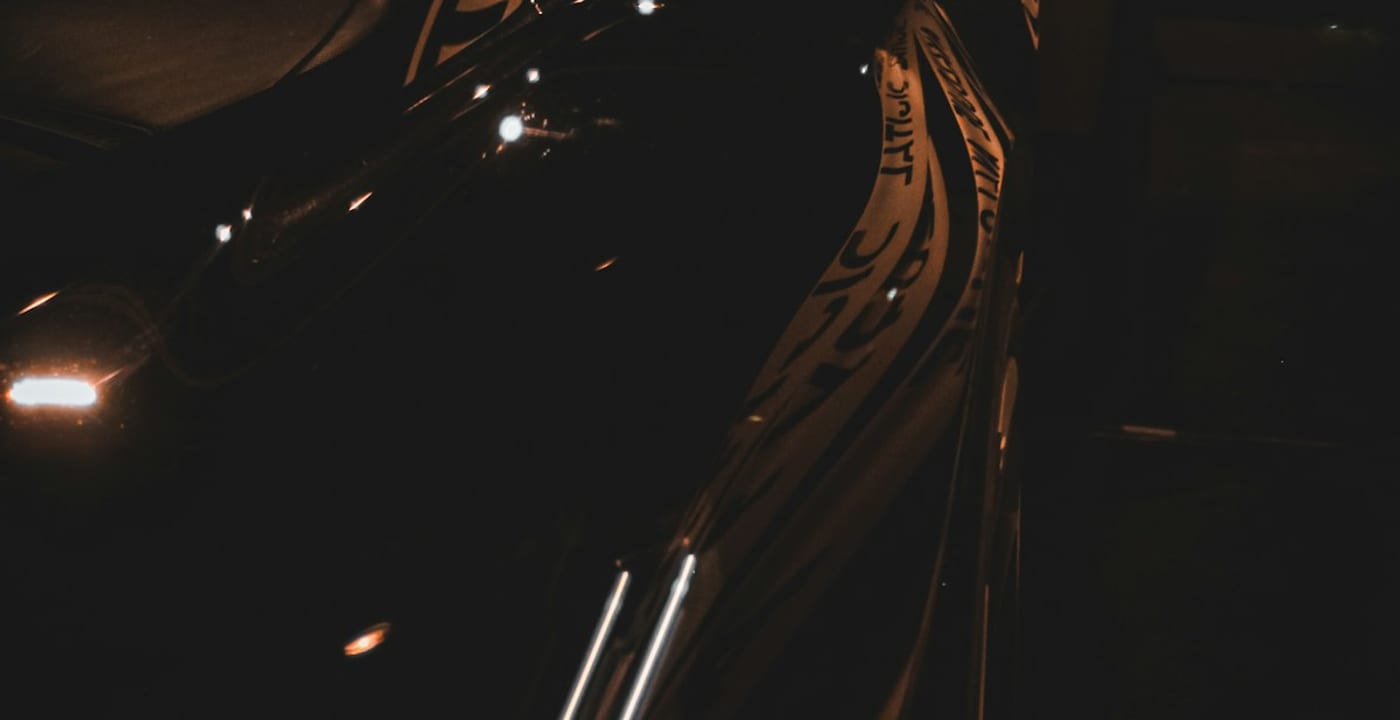 Detail of a glossy black vehicle under warm studio light